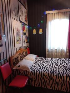 sypialnia z łóżkiem z wzorem zebry i oknem w obiekcie Сибиряк w mieście Ckaltubo