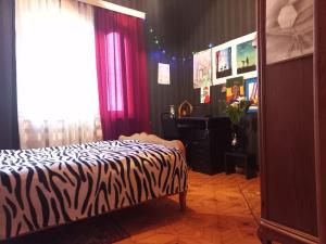 een slaapkamer met een bed met zebraprint en een piano bij Сибиряк in Tskaltubo