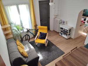 salon z kanapą i żółtym krzesłem w obiekcie Chambres tranquilles proche centre ville w mieście Arles