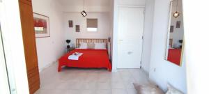 1 dormitorio con 1 cama roja en una habitación blanca en Villa Βianca in Sithonia, en Gerakini