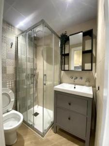 uma casa de banho com um chuveiro, um lavatório e um WC. em coqueto apartamento en Sevilla em Sevilha