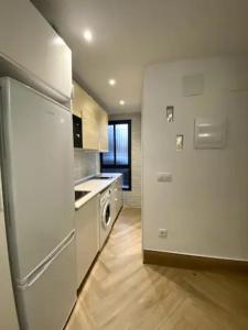 uma cozinha com um frigorífico branco e piso em madeira em coqueto apartamento en Sevilla em Sevilha