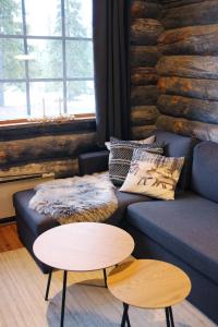 a living room with a blue couch and a table at Holiday Home Vonkamies in Luosto