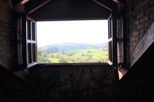 une fenêtre dans un bâtiment avec vue sur un champ dans l'établissement La Venta de Quijas, à Quijas