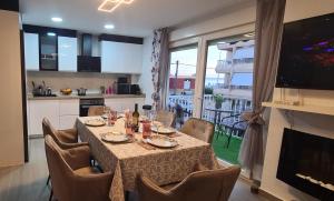 a dining room with a table and chairs and a kitchen at Emma Apartman in Santa Pola