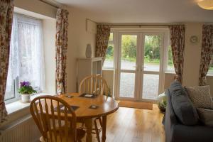 a living room with a table and a couch at Highfield Cottage in West Hallam