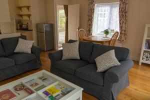 a living room with a couch and a table at Highfield Cottage in West Hallam