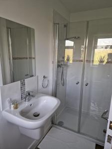 a white bathroom with a shower and a sink at Swan Retreat in Taunton