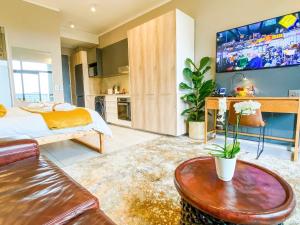 a bedroom with a bed and a table and a tv at Menlyn Maine Residences - Napoli with king sized bed in Pretoria