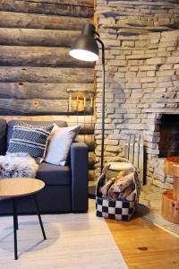 a living room with a blue couch and a stone wall at Holiday Home Vonkamies in Luosto