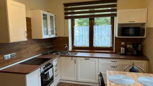 a kitchen with white cabinets and a sink and a window at Nad Białką in Bielsko-Biała
