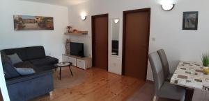 una sala de estar con un sofá y una mesa en Apartments Radović, en Labin