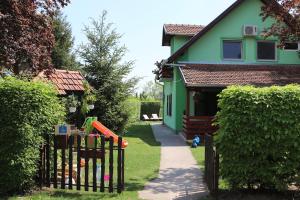 a green house with a fence and a playground at Green Harmony in Palić