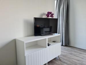 a white entertainment center with a flat screen tv at Tiny house in de Achterhoek in Voorst