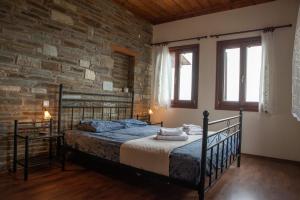 a bedroom with a bed in a brick wall at Notas Pelion Seaview Villa in Zagora