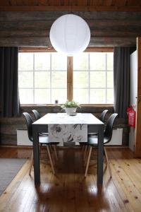 a dining room with a white table and chairs at Holiday Home Vonkamies in Luosto