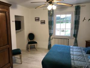 a bedroom with a blue bed and a window at la forge de Clermont in Clermont