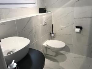 a white bathroom with a toilet and a sink at la forge de Clermont in Clermont +10 photos