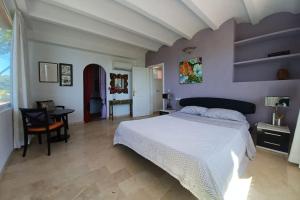 a bedroom with a large white bed and a desk at Can reganes in Sant Josep de sa Talaia