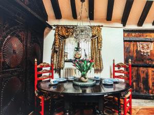 a dining room with a table and chairs and a chandelier at Priory House B&B And The Oriental Brewhouse Self Catering Accommodation in Long Bennington