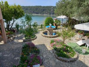 a garden with a fountain and flowers and a lake at Cosy room Arba with private bathroom and sea view in Kampor