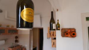 eine Flasche Wein, die an einer Leuchtvorrichtung hängt in der Unterkunft Appartamento Arte e Mare in Bordighera