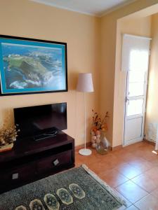 un soggiorno con TV a schermo piatto e tavolo di Hospedaje familiar en un enclave privilegiado a La Coruña
