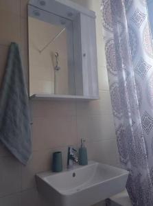 a bathroom with a sink and a shower curtain at Homes near Golf The Elysian Beauty of Ermones in Vátos