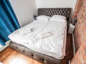 a bed in a room next to a brick wall at Dworcowa Centrum Apartament in Bydgoszcz