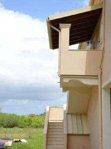 a balcony of a building with a view of a field at Homes near Golf The Elysian Beauty of Ermones in Vátos