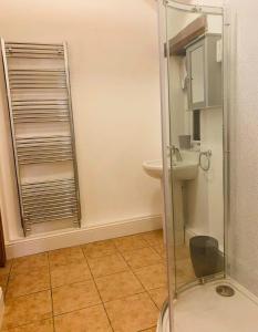 a bathroom with a toilet and a glass shower at Oxley Cottage in Alford