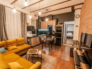 sala de estar con sofá amarillo y cocina en Dworcowa Centrum Apartament, en Bydgoszcz