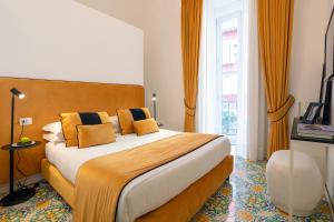 um quarto de hotel com uma cama grande com almofadas amarelas em relais metis em Nápoles