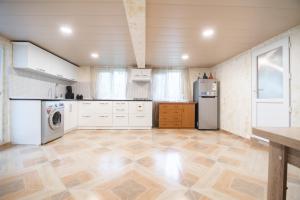 a large kitchen with white cabinets and a refrigerator at Cozy apartment near Kobuleti with mountain view in K'obulet'i