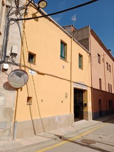 um edifício amarelo no lado de uma rua em Can Pitu Ferrer em Peralada