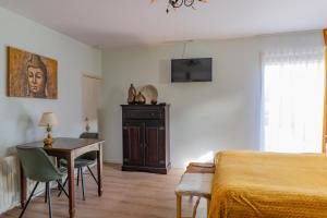 a bedroom with a bed and a table and a desk at B&B De Buren in Gasselte