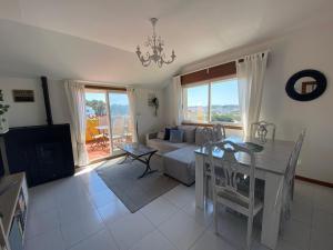Sala de estar con cama y mesa de comedor en Bonito apartamento en la playa, en Sanxenxo