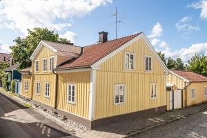 uma casa amarela ao lado de uma rua em Central lägenhet i nyrenoverat 1700-talshus em Västervik