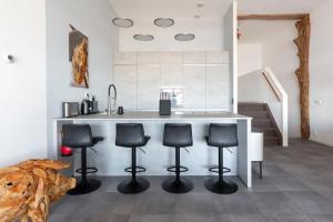 eine Küche mit einer Theke mit vier Stühlen drum herum in der Unterkunft Appartement in Zeeland - Kabbelaarsbank 506 - Port Marina Zélande - Ouddorp - not for companies in Ouddorp