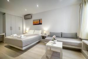 ein Hotelzimmer mit einem Bett und einem Sofa in der Unterkunft Anius Apartments in Mykonos Stadt