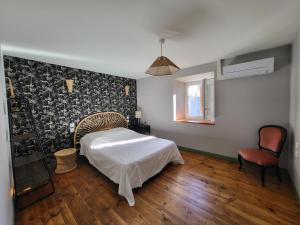 1 dormitorio con 1 cama, 1 silla y 1 ventana en Gîte PRAT NAOU - PYRENNEES ARIEGEOISES, en Taurignan-Vieux