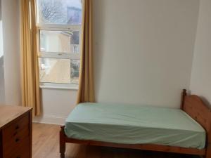 sypialnia z łóżkiem obok okna w obiekcie Burney Tomar House w mieście Croydon