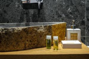 łazienka z umywalką i 2 butelkami alkoholu w obiekcie Anius Apartments w mieście Mykonos +37 zdjęć