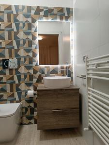 ein Bad mit einem Waschbecken und einem Spiegel in der Unterkunft VSuites in Cagliari