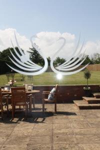 a woman sitting on a bench in front of a sculpture at Swan Retreat in Taunton