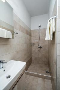 ein Bad mit einer Dusche und einem Waschbecken in der Unterkunft Villa MARIA in Nea Vrasna