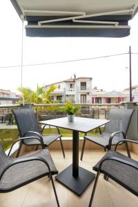 einen Tisch und Stühle auf einem Balkon mit einem Tisch in der Unterkunft Villa MARIA in Nea Vrasna