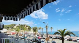 een uitzicht op een parkeerplaats met palmbomen en de oceaan bij Happy LLoret in Lloret de Mar