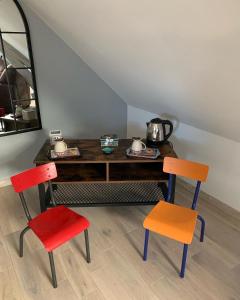 Habitación con 2 sillas y mesa con espejo. en Ecole de Mathuna de Marigny Brizay, en Marigny-Brizay