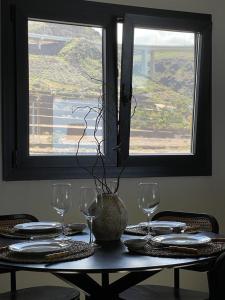 una mesa con vasos y platos y una ventana en Casa Lúa en Santa Maria de Guia de Gran Canaria
